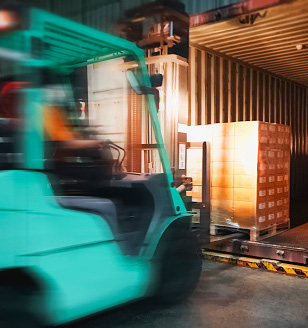 Forklift loading LTL freight shipment at warehouse